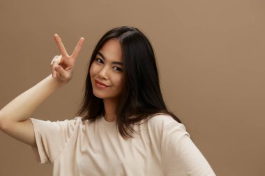 Bej tişörtlü güzel bir kadın moda stüdyosu modeli pozu veriyor. Yüksek kalite fotoğraf