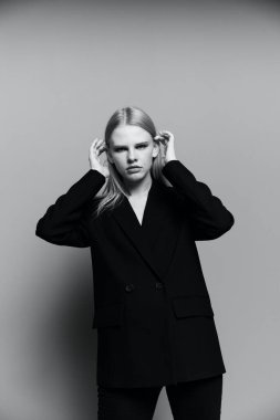 Markalar için harika bir teklif. Özel tasarım takım elbiseli bir kız stüdyoda poz veriyor. Yüksek kalite fotoğraf