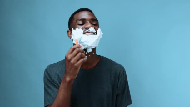 Afro Amerikai Férfi Borotvával Borotválja Szakállát Borotvahabbal Kék Hátterű Pólóban — Stock videók