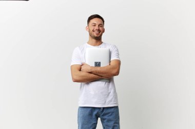 Basit tişörtlü neşeli, bronzlaşmış yakışıklı adam beyaz stüdyo arka planında yalnız poz veren dizüstü bilgisayarlı sarılıyor. Uzayın afiş modelini kopyala. Elektronik tamir Gadget yaşam tarzı konsepti