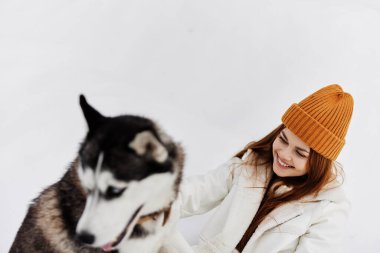 Karda bir kadının portresi köpek arkadaşlığı kış tatilinde eğlencesine oynuyor. Yüksek kalite fotoğraf