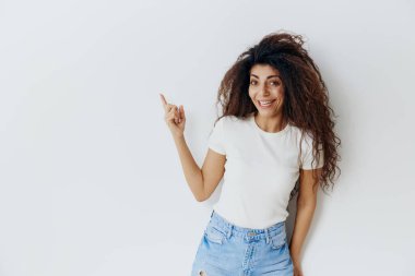 FASHION Yaz Satışı Teklifi. Neşeli, gülümseyen kıvırcık Latin kadın yeşil duvarın yanında kalıyor, 