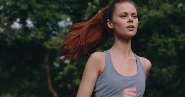 公園で朝のジョギングをしている女性が 木の背景を追跡している ライフスタイルとしてのスポーツの概念 高品質の4K映像 — ストック動画
