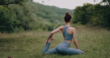 Bir kadın dışarıda jimnastik minderinde egzersiz yapar ve bacak kaslarını spor küpleri üzerine gerer. Spor Yaşam Tarzı. Yüksek kalite 4k görüntü