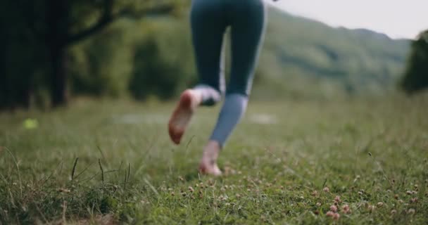 女性は野外公園で緑の草の上を裸足で走っている 自然との調和という概念 高品質の4K映像 — ストック動画