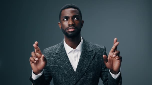 Man african american businessman holding hands up with fingers crossed for good luck before important meeting at work. High quality 4k footage