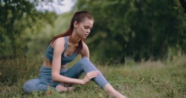 Spor, dinlenme ve sağlık hizmetlerinden sonra parkta bacak kaslarına masaj yapan bir kadın. Yüksek kalite 4k görüntü