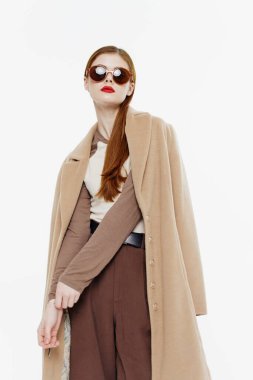 Beyaz arka planda gözlüklü ve ceketli şık kızıl saçlı bir bayan. Yüksek kalite fotoğraf