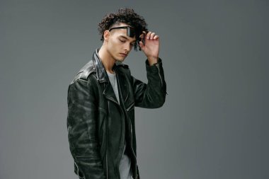 Gri stüdyo arka planında izole edilmiş şık, bronzlaşmış, deri ceketli, moda güneş gözlükleri. Güzel moda teklifi. Büyük Mevsimlik Satış Yeni Koleksiyon konsepti. İlan için alanı kopyala