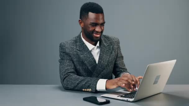 아프리카계 미국인 사업가가 책상에 사무실에 앉아서 노트북을 비즈니스복을 미소를 지으며 — 비디오