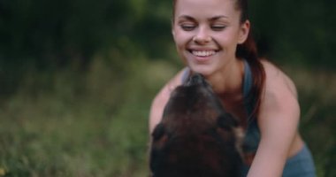 Kadınlar spor antrenmanlarından sonra parkta köpeklerle oynarlar eşofman ve gülümsemeyle. Yüksek kalite 4k görüntü