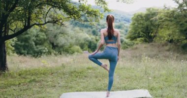 Parkta eşofmanla yoga yapan sporcu bir kadın. Meditasyon bir yaşam tarzı. Yüksek kalite 4k görüntü