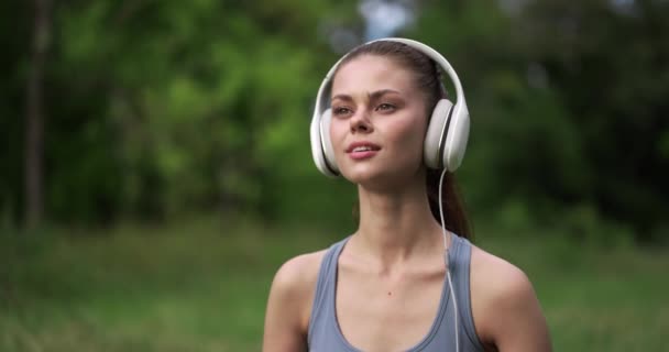 Молодая Женщина Отдыхает Траве После Спортивных Тренировок Парке Слушает Улыбающуюся — стоковое видео