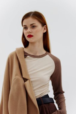 Stüdyoda beyaz arka planda bej tek omuzlu bir kız. Yüksek kalite fotoğraf