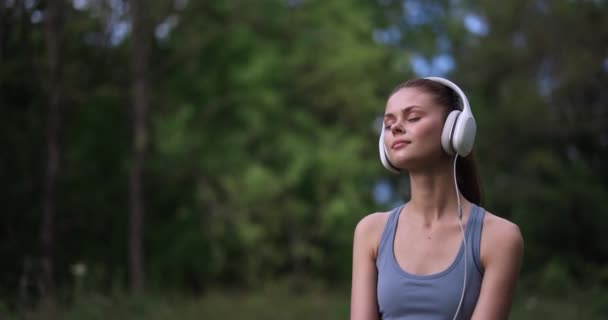 Een Vrouw Zit Het Gras Natuur Luistert Naar Meditatieve Muziek — Stockvideo