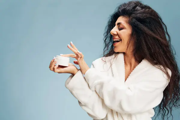 Side View Cheerful Curly Latin Lady Bathrobe Using Facial Cream — Stock Photo, Image