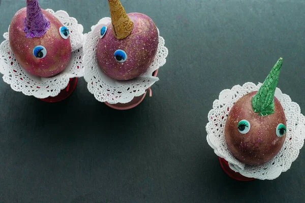 Смешные единороги космоса пасхальные три яйца с красочными рогами и игрушечные глаза на черном фоне. — стоковое фото