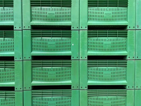 Yeşil renk yığını yeni plastik ambalaj sandıkları arka planı.