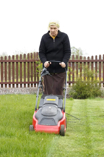 Alte Frau mäht Gras — Stockfoto