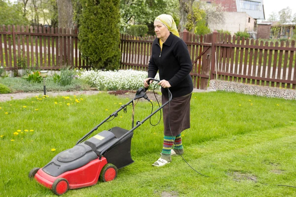 Old woman mowing grass — Stock Photo, Image