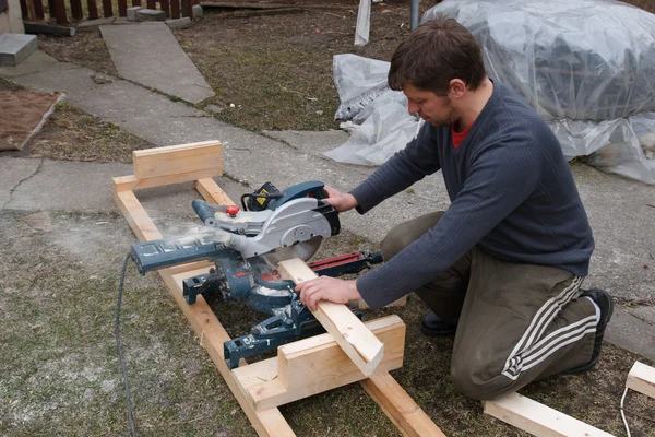 Carpenter sawing plank — Stock Photo, Image