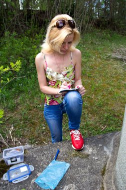 kadın geocaching logbook yazıyor