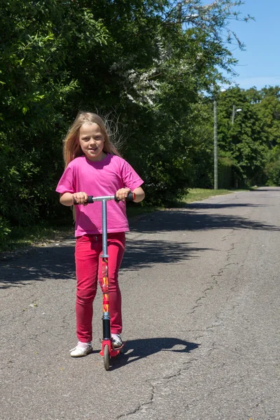 Little girl rides a scooter — Stock Photo, Image