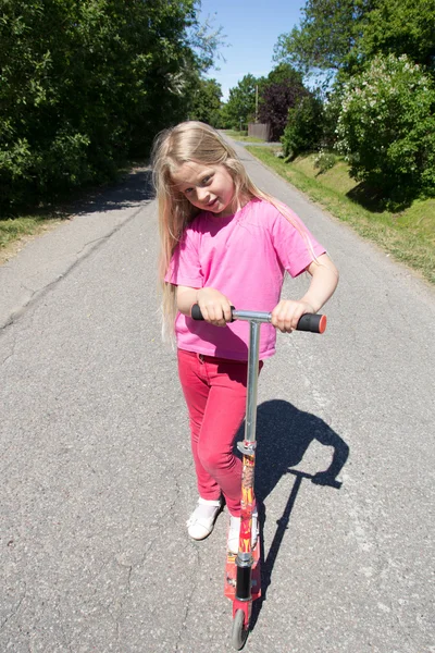 Little girl rides a scooter — Stock Photo, Image