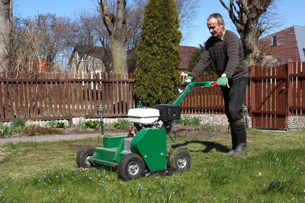 Man som arbetar med gräsmatta strålsamlare — Stockfoto