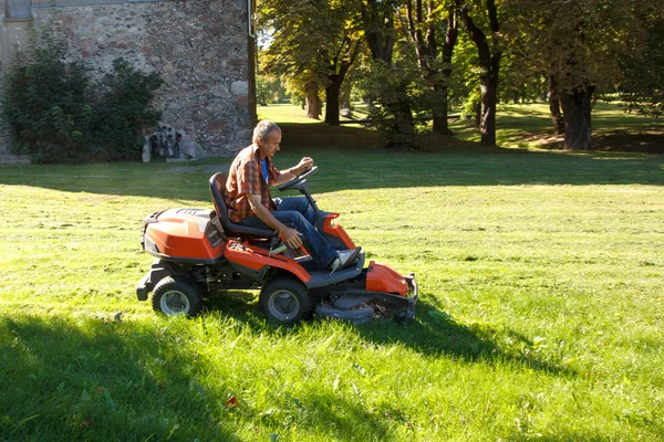 Man rijden een rode grasmaaier (trekker) — Stockfoto