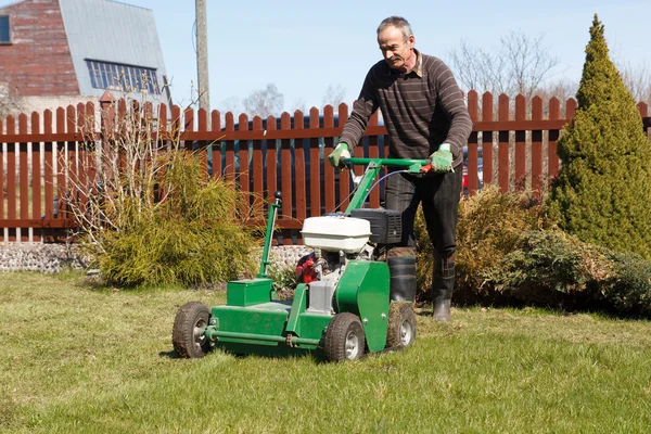 Man som arbetar med gräsmatta strålsamlare — Stockfoto