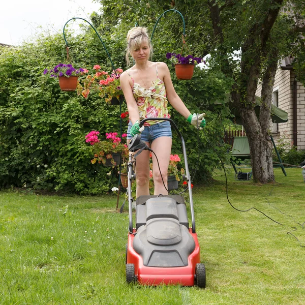 芝生芝刈り機を持つ女性 — ストック写真