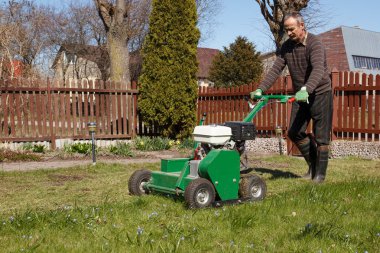 Man working with Lawn Aerator clipart