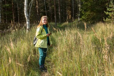 Kadın Geocaching oynuyor. Ormanın derinliklerinde yürü.