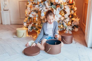 Noel arifesinde evde elinde maytap olan küçük bir kız. Açık renk yatak odalı, kış dekorasyonlu küçük bir çocuk. Mutlu bir aile. Noel Yeni Yıl Kutlama Konsepti Zamanı