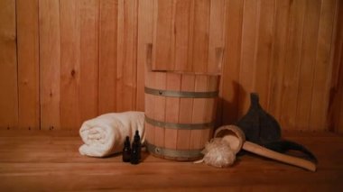 Geleneksel eski Rus hamamı SPA konsepti. Finlandiya sauna saunasında geleneksel sauna aksesuarları ve havlunun aromalı yağ kepçesi kullanılmış. Rahatlayın köy banyosu konsepti.