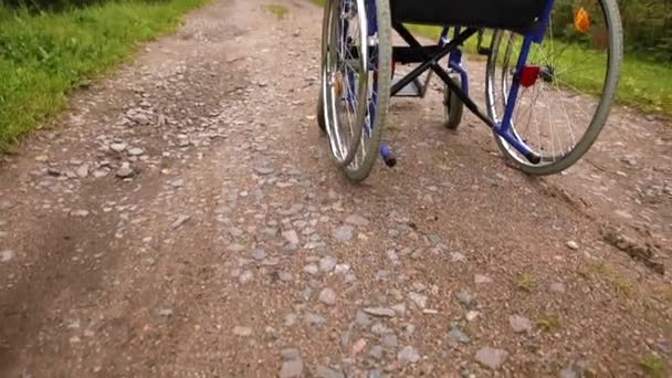Prázdný invalidní vozík stojí na silnici a čeká na služby pro pacienty. Neplatné křeslo pro osoby se zdravotním postižením zaparkované venku v přírodě. Bezbariérový symbol přístupný. Zdravotní péče lékařské koncepce. — Stock video