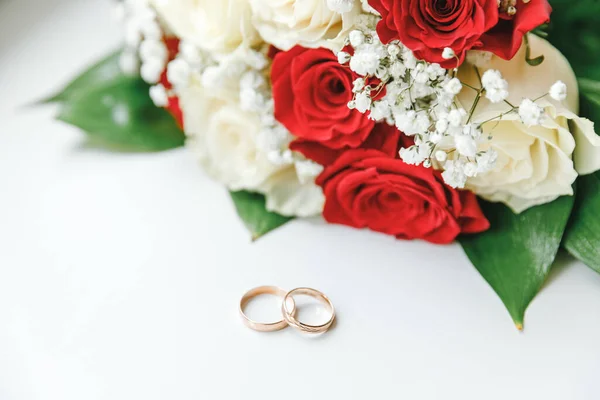 Zlaté Snubní Prsteny Květiny Kytice Bílé Červené Barvy Ležící Bílém — Stock fotografie