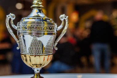 Soyut koyu arkaplanı bulanık altın kupa sahibi ya da şampiyon. Yarışmanın birinciliği. Kazanma ya da başarı kavramı