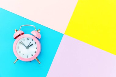 Çalan ikiz çan klasik alarm saati mavi pembe renkli renkli geometrik arkaplanda izole edilmiş. Hayatın dinlenme saatleri. İyi sabahlar. Uyanık kalma kavramı. Düz görünüm kopyalama alanı