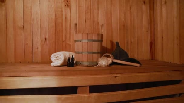 伝統的なロシアの古い浴場SPAの概念。室内詳細伝統的なサウナ付きのフィンランド式サウナスチームルームでは、洗面タオルアロマオイルスクープを感じました。田舎の村のバスコンセプトをリラックス. — ストック動画