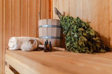 Geleneksel eski Rus hamamı SPA konsepti. İçişleri, geleneksel sauna aksesuarlarıyla Finlandiya sauna sauna saunası havlusu aromalı havluyla döşenmiş. Rahatlayın köy banyosu konsepti.