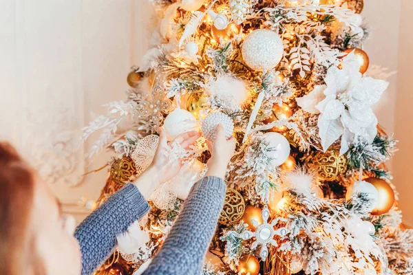 Menina decorando árvore de Natal na véspera de Natal em casa. Jovem em quarto leve com decoração de inverno. Família feliz em casa. Natal Ano Novo dezembro tempo para celebração conceito. — Fotografia de Stock