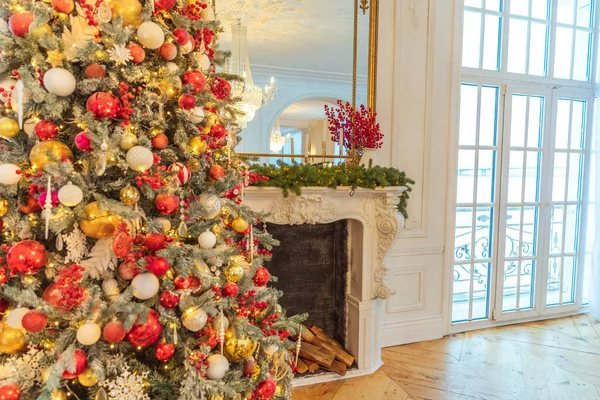 经典的圣诞装饰室内装饰 新年树与红色和金色装饰 现代白色古典风格室内设计公寓与壁炉和圣诞树 平安夜在家里 — 图库照片