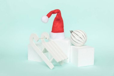 Kısaca kış nesneleri süslemesi ve küp şekilleri geometrik form podyumu izole edilmiş mavi pastel arka plan. Noel, yeni yıl kutlamaları için aralık zamanı. Kopyalama alanı