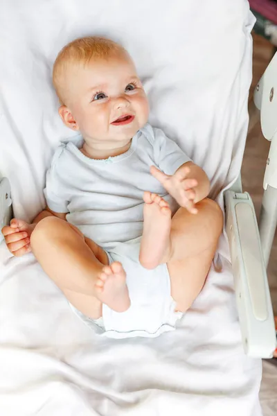얼굴로 카메라를 귀여운 신생아 아기는 의자에 때놀고 있습니다 어머니의 — 스톡 사진