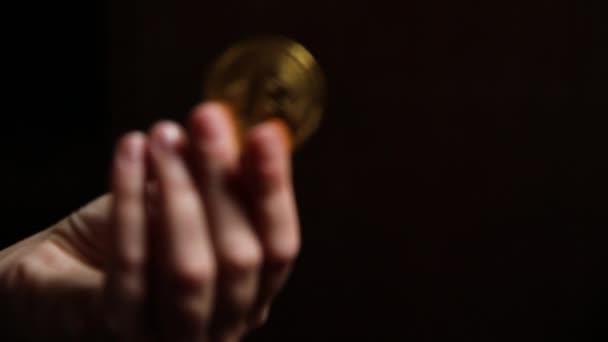 Žena ruka drží kryptoměna zlaté bitcoin na tmavém pozadí. Elektronické virtuální peníze pro internetové bankovnictví a mezinárodní síťové platby. Symbol virtuální měny crypto. Koncept těžby. — Stock video