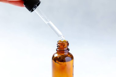 Gerekli yağ pipetten şişeye dökülüyor. Esans sıvı kozmetik. Sıvı kozmetik serumlu damlatan cam şişe. Şurup parfümü aromaterapi konsepti. Güzellik Tedavisi