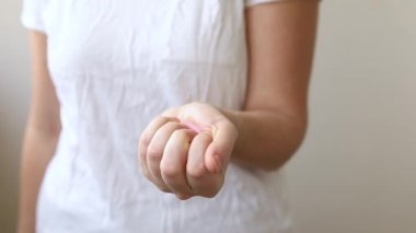 Beyaz arka planda pembe regl bardağını tutan kadın. Adet döneminde modern kadın alternatif jinekolojik hijyen. Kız elinde kan kabı.