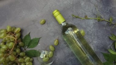 Şişe beyaz şarap, yeşil şarap, şarap kadehi ve eski gri taş masa zemininde olgun üzüm. Şarap dükkanı şarap dükkanı ya da şarap tatma konsepti.